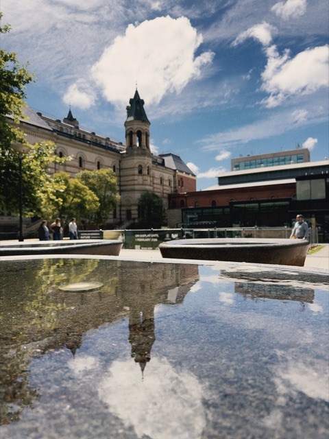 A clock tower reflected in still water