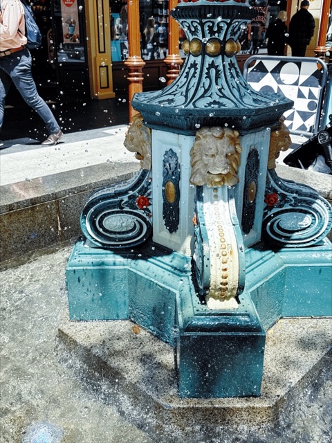 An old teal fountain splashing water